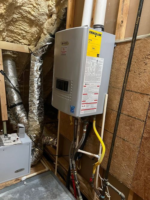 Electrical breaker panel mounted on a wall in an unfinished basement with exposed insulation and wiring.