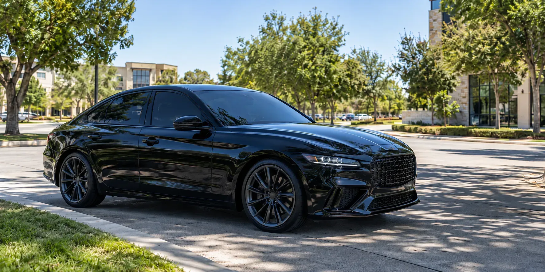 Freshly tinted black sedan parked on a sunny Richardson, Texas street in bright Texas sun.