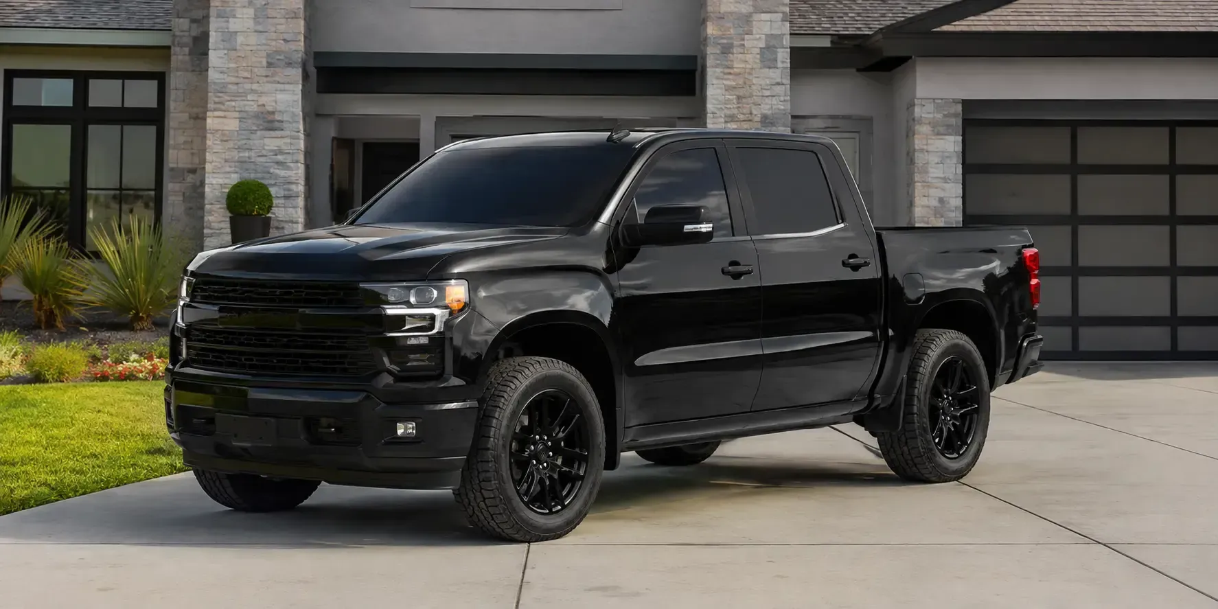 A beautifully tinted black pickup truck parked in front of a modern residential home, showcasing enhanced privacy and a sleek, professional appearance.