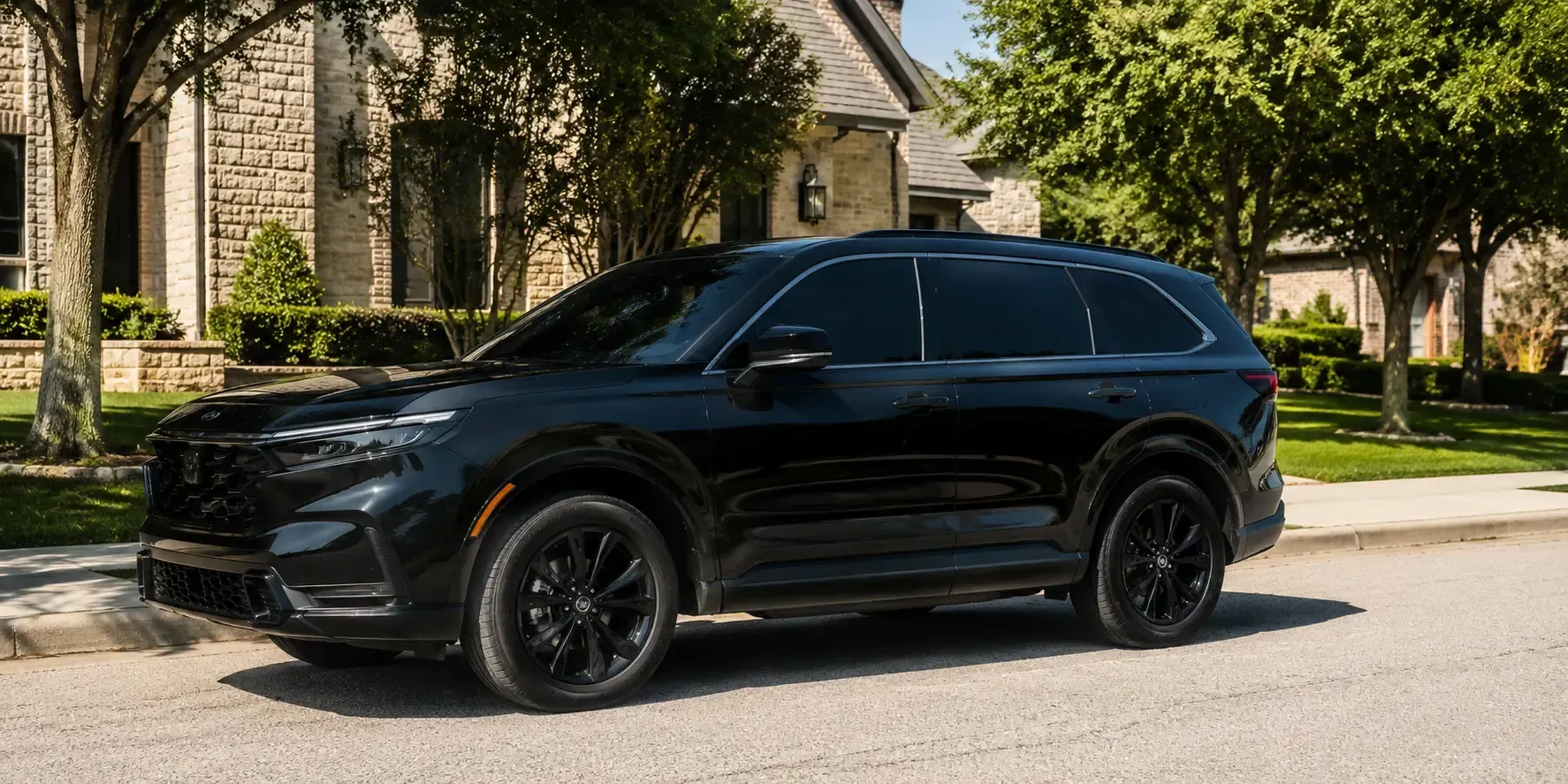 Freshly tinted dark SUV parked on a sunny, upscale residential street in McKinney, Texas.