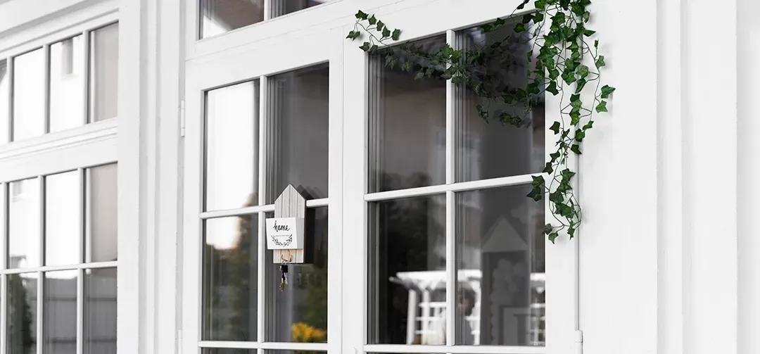 A white building with a lot of windows and ivy growing on it.