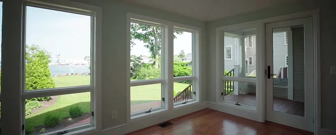 An empty room with a lot of windows and sliding glass doors.