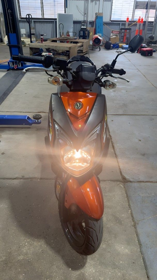 A Motorcycle is Parked in a Garage With Its Headlights on — Skids Mechanical Services Pty Ltd in Wagga Wagga, NSW