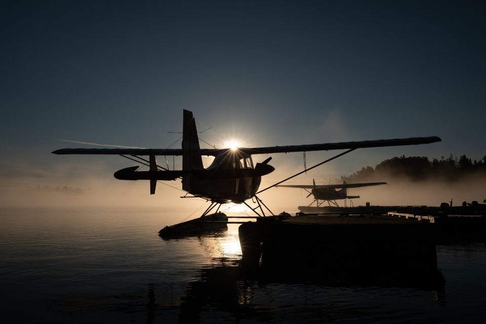 A float plane is docked at a dock in the water at night.
