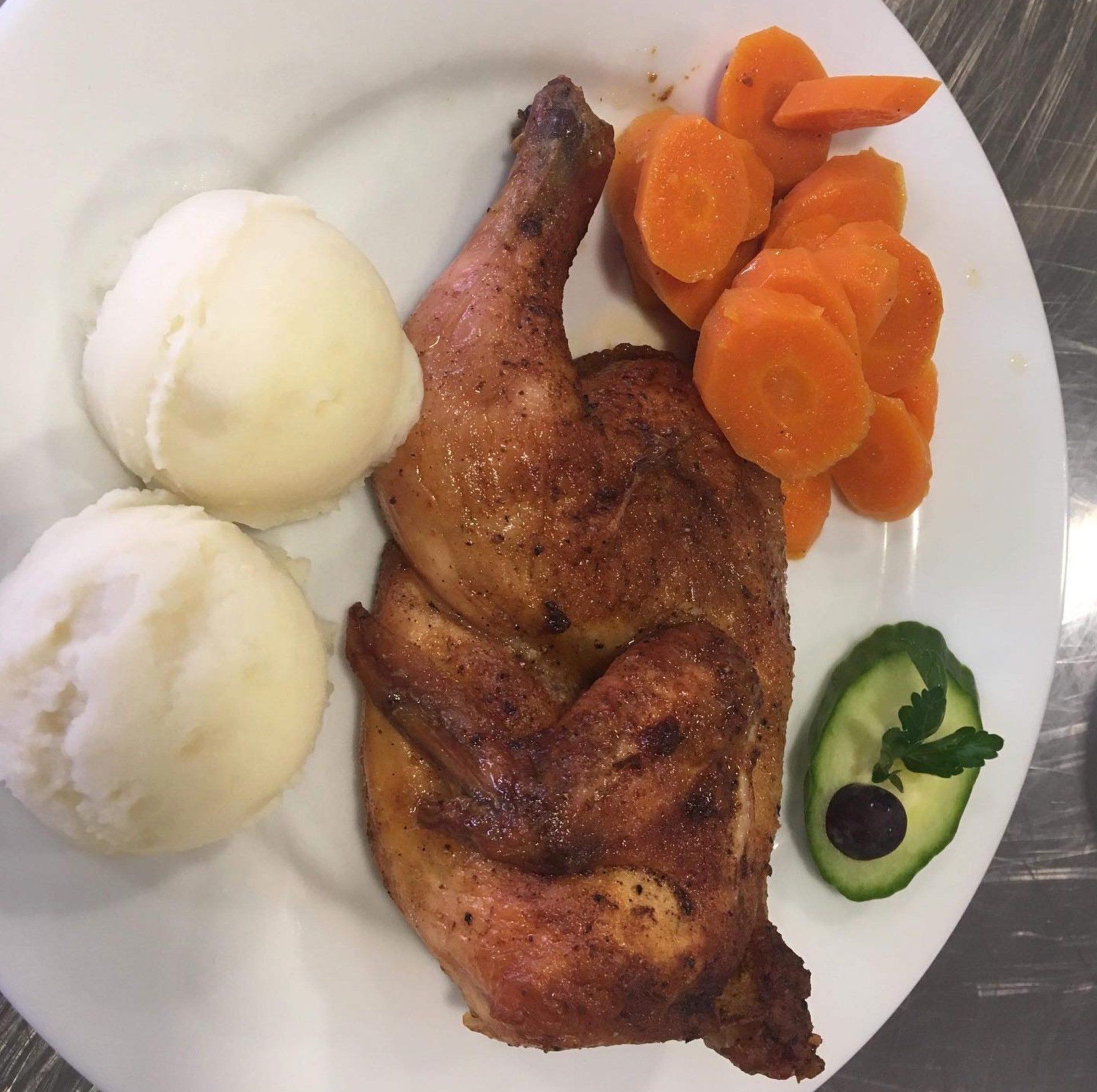 A white plate topped with chicken carrots and mashed potatoes