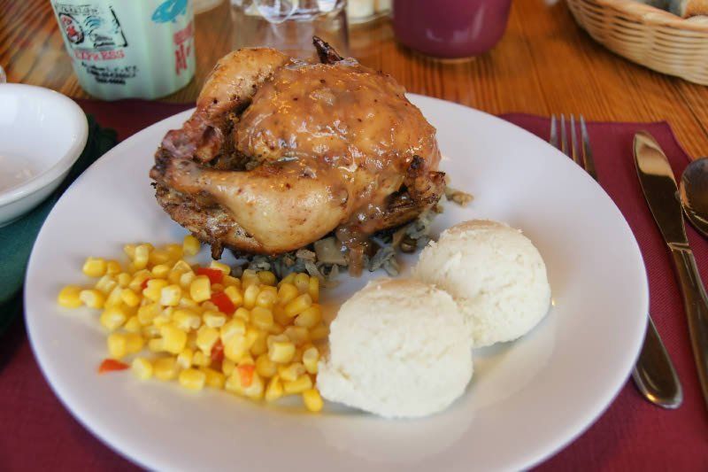 A white plate topped with chicken corn and mashed potatoes