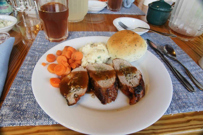 A plate of food with meat , carrots and mashed potatoes on a table.