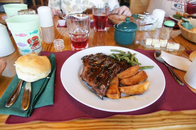 A plate of food on a table with a biscuit and green beans