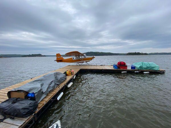 A small plane is sitting on a dock in the middle of a lake.