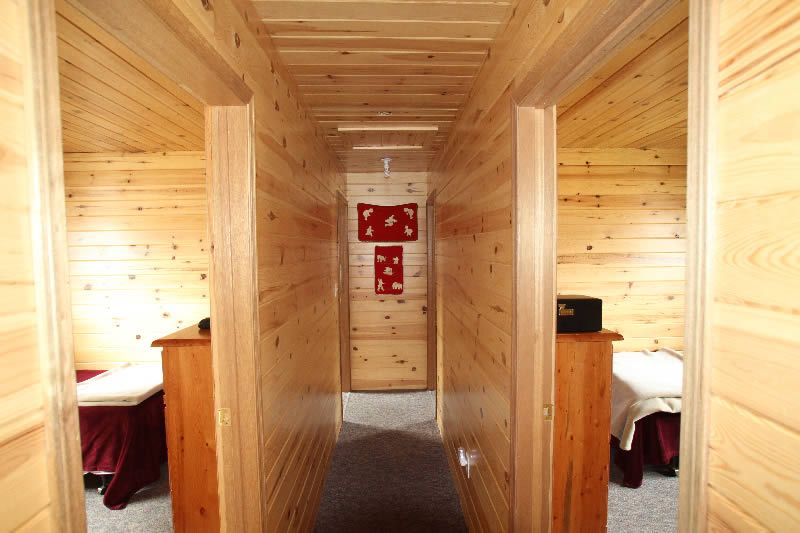 A hallway in a log cabin with two beds