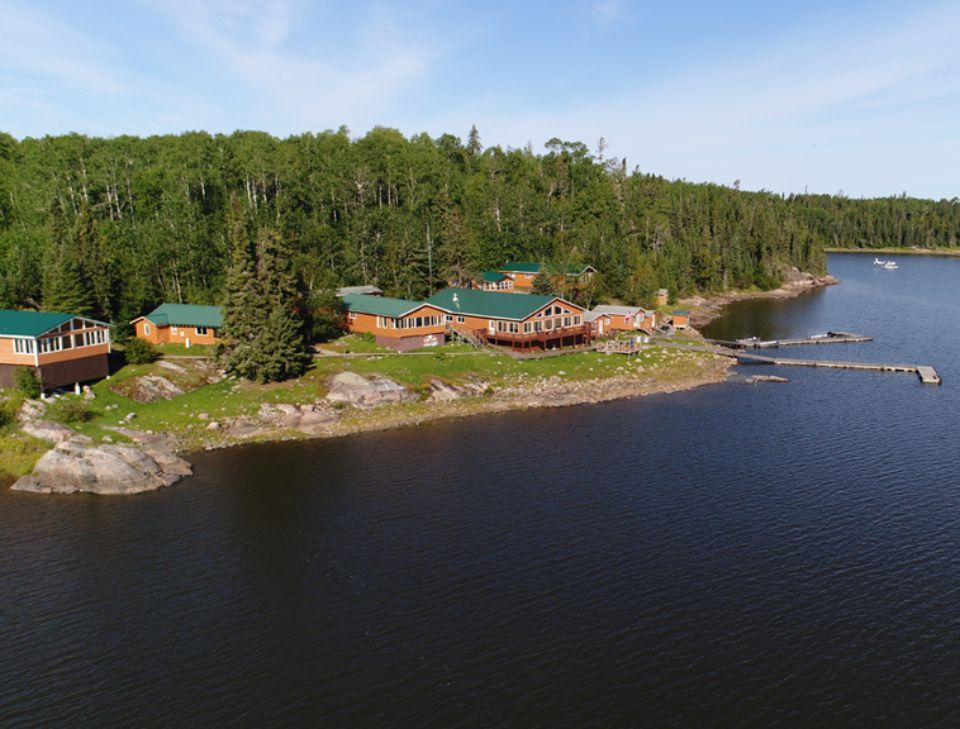 An aerial view of a cabin on the shore of a lake