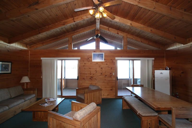A living room with a table and chairs and a ceiling fan
