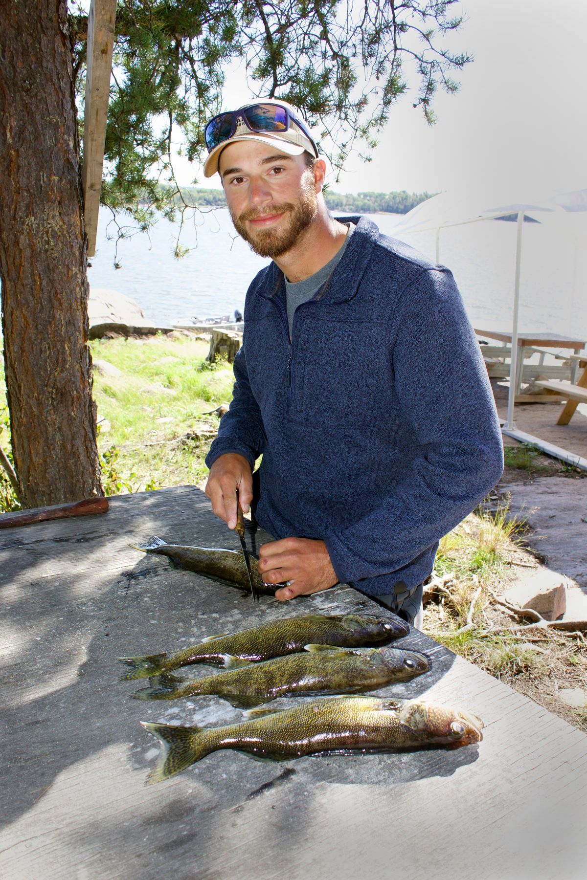 Filleting walleye fish at the shore lunch on Oak Lake Lodge.