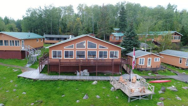 A group of cabins are sitting on top of a lush green field.