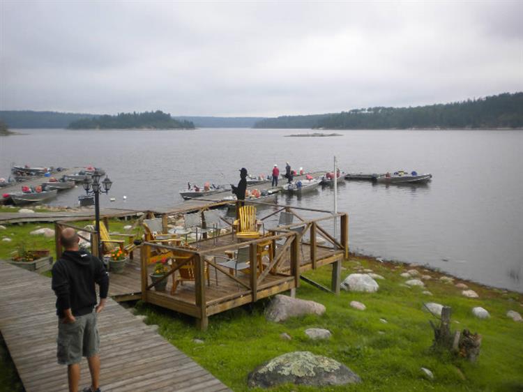 A man is standing on a dock overlooking a lake.