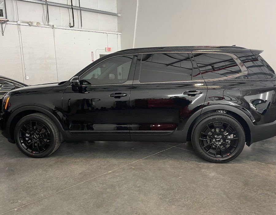 Black Kia Telluride SUV with tinted windows and black wheels.