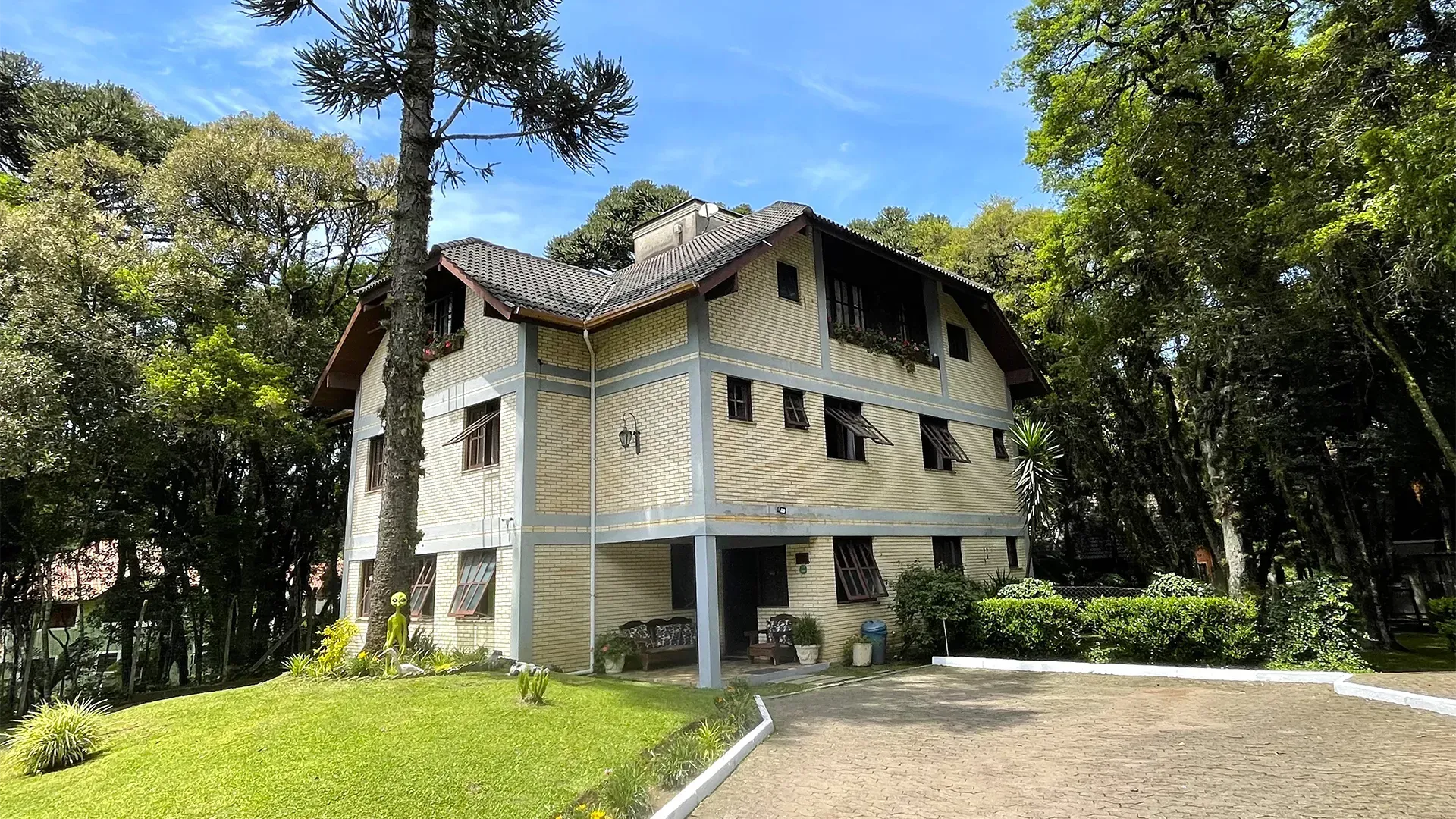 Um prédio com telhado de palha e uma palmeira ao fundo