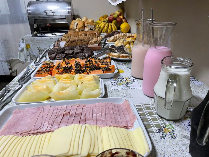 Um pátio com cadeiras e uma mesa com um barco ao fundo.