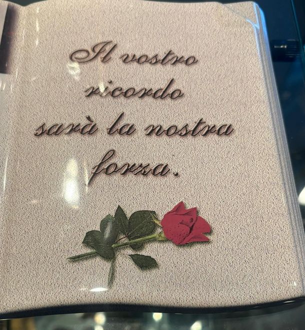 Lapide in marmo chiaro con dettagli di intaglio in un cimitero ordinato