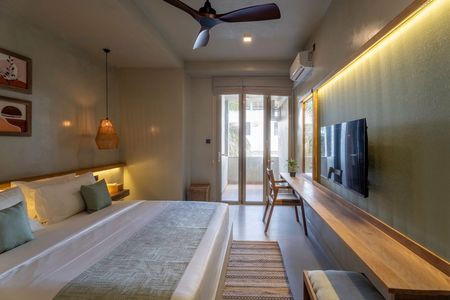 Modern bedroom with bed, wall-mounted TV, warm lighting, and balcony doors
