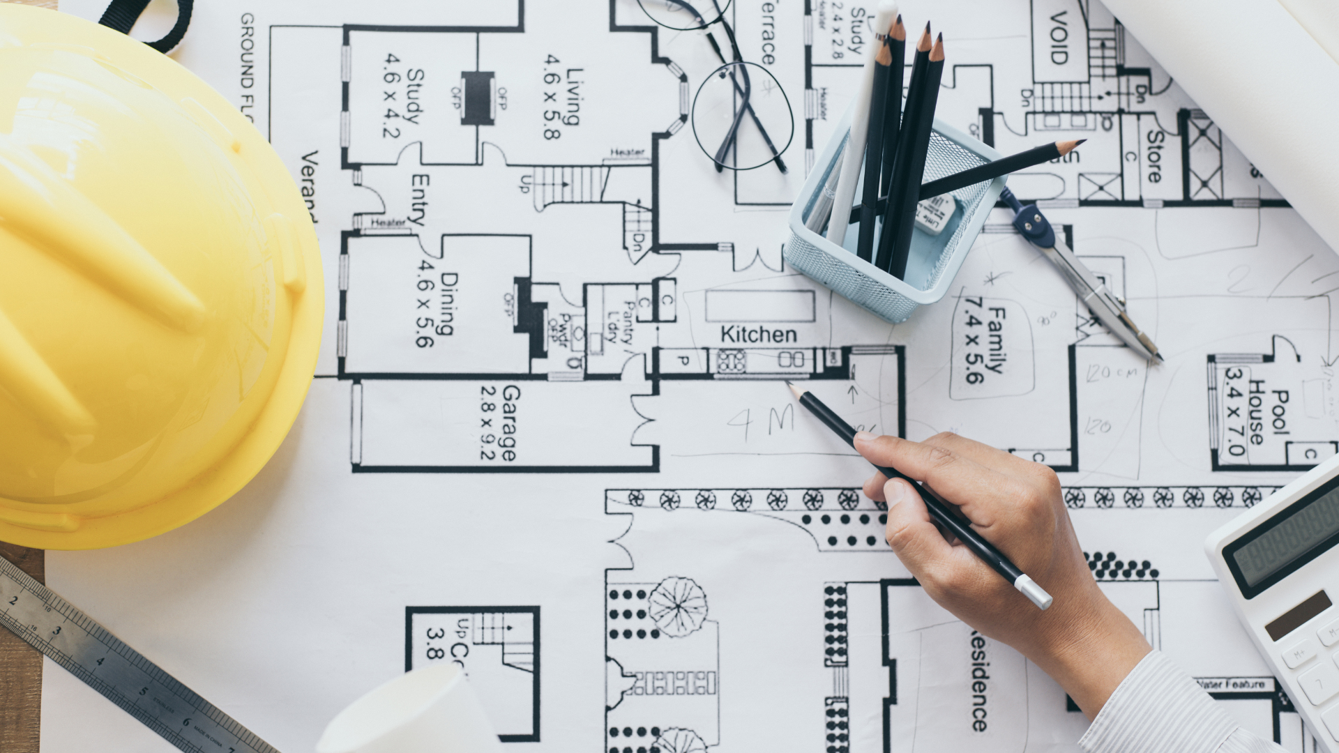 A person is drawing a floor plan of a house.
