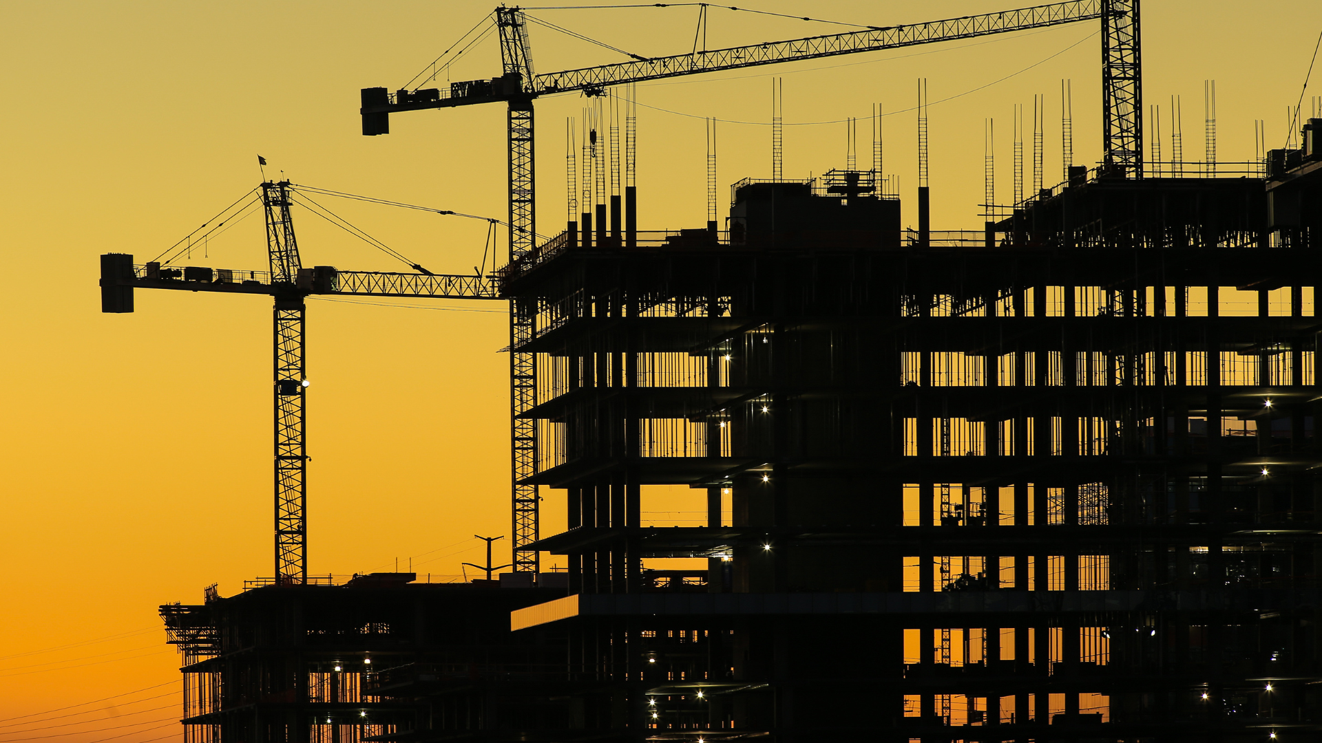 A construction site with cranes and a building under construction