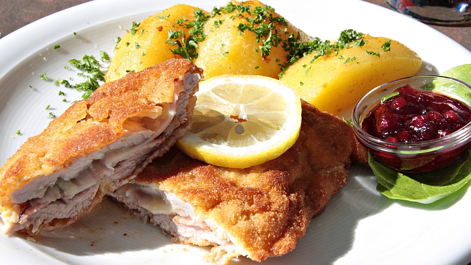 Ein Putenschnitel mit Kartoffeln, Preiselbeeren und Zitrone