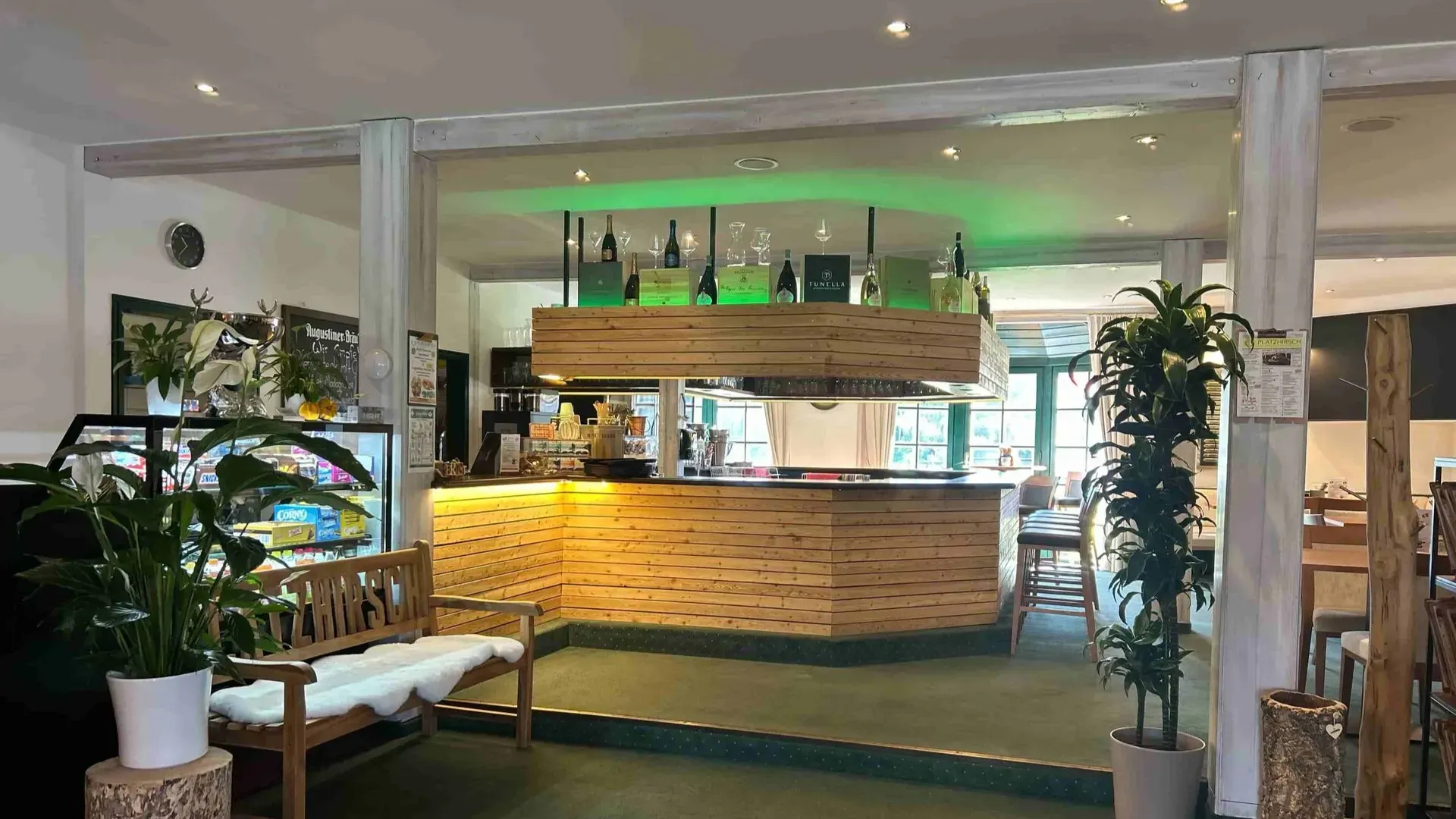 Barbereich des Restaurants Platzhirsch in Olching mit Sitzplätzen und grüner Beleuchtung.
