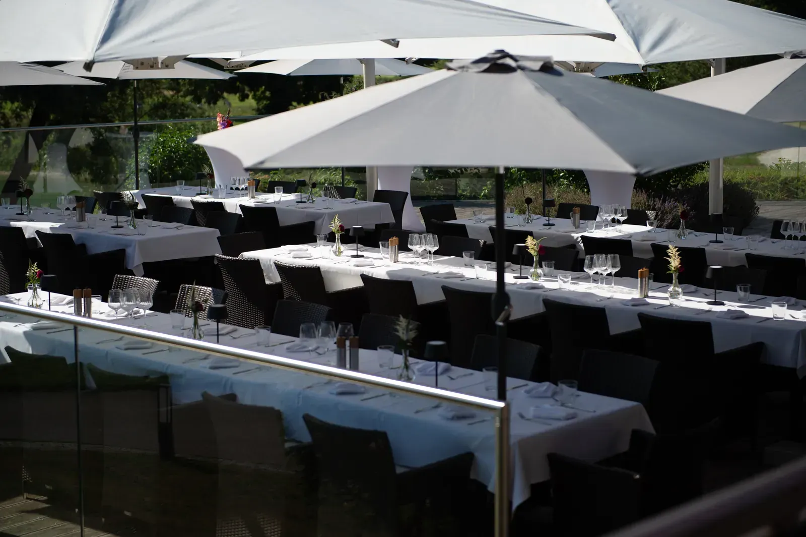 Festlich eingedeckte lange Tafeln unter Sonnenschirmen auf der Terrasse des Platzhirsch Olching