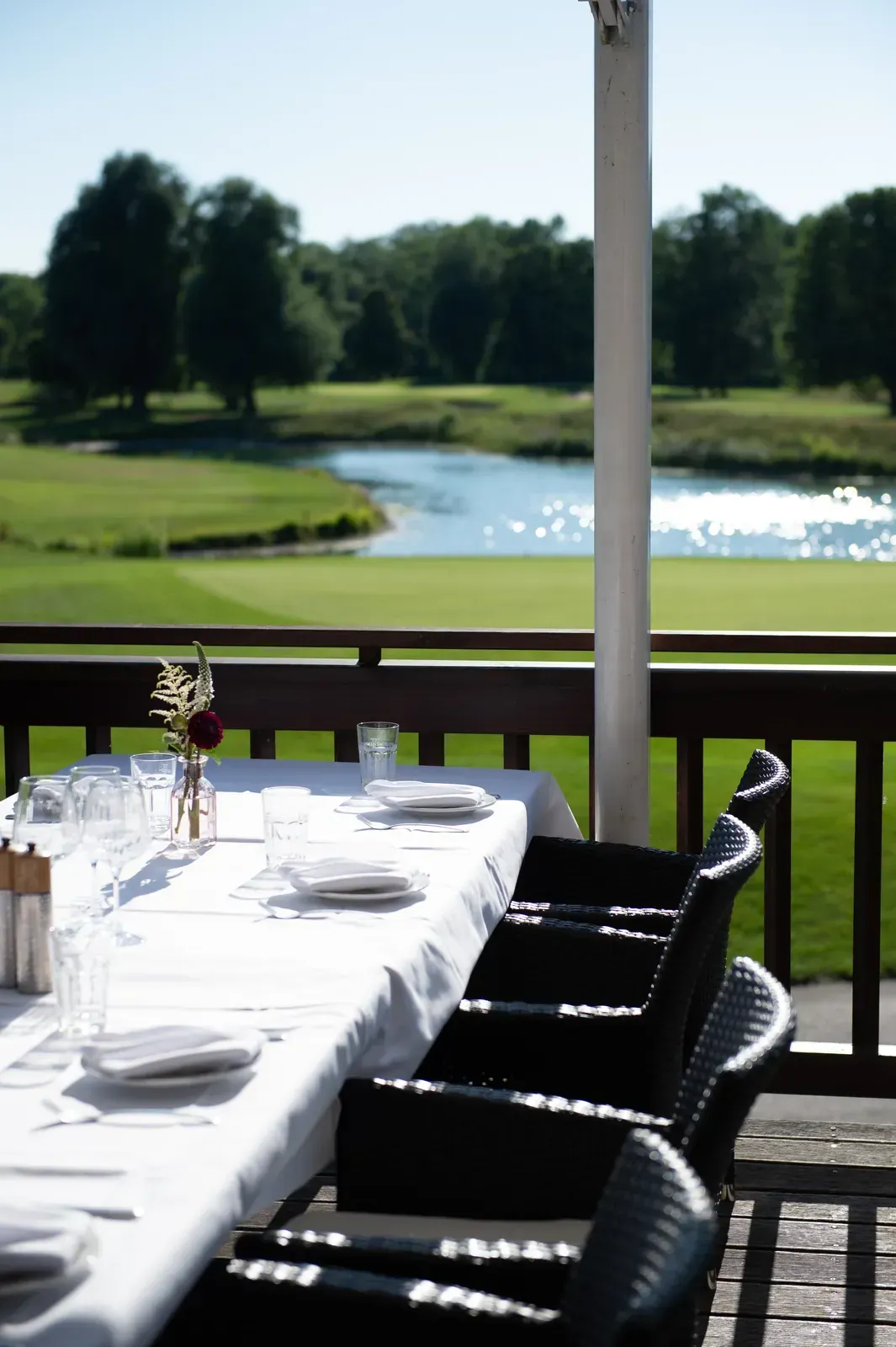 Gedeckte Tafel auf der Terrasse mit Blick auf See und Golfplatz Olching