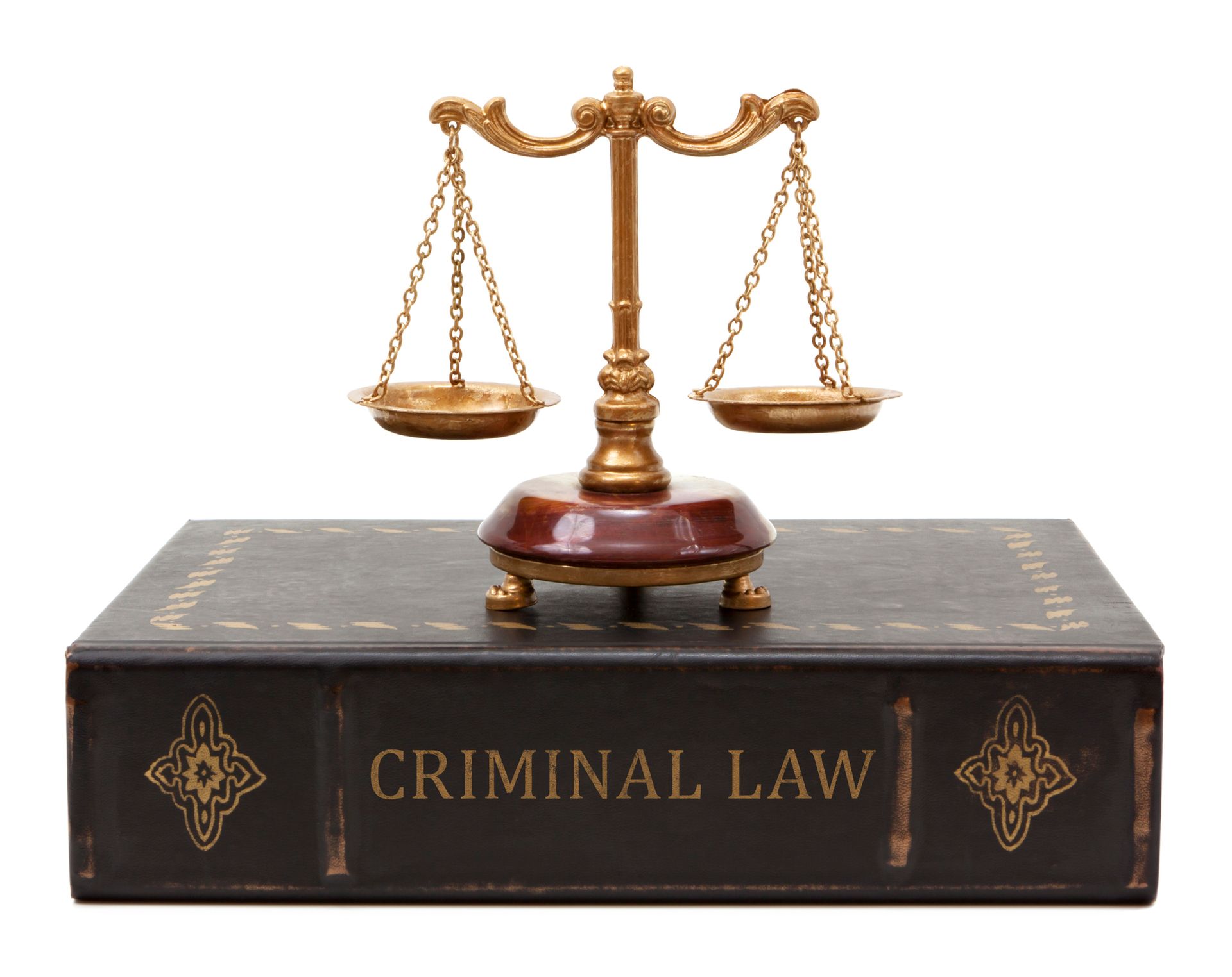 Old criminal law book with weathered spine beside balanced scales of justice.