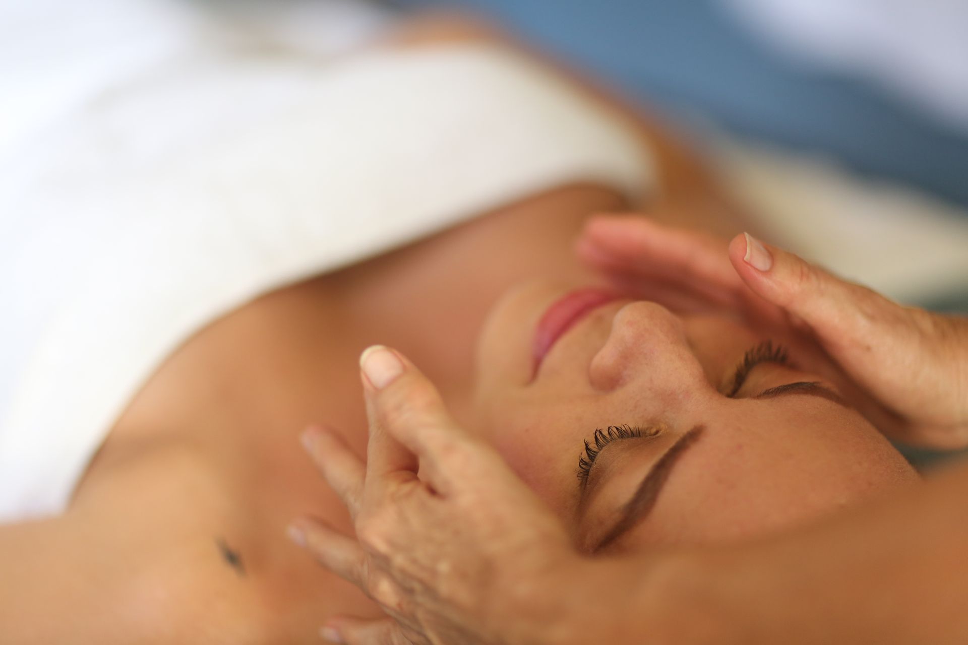 A woman is getting a facial massage at a spa.