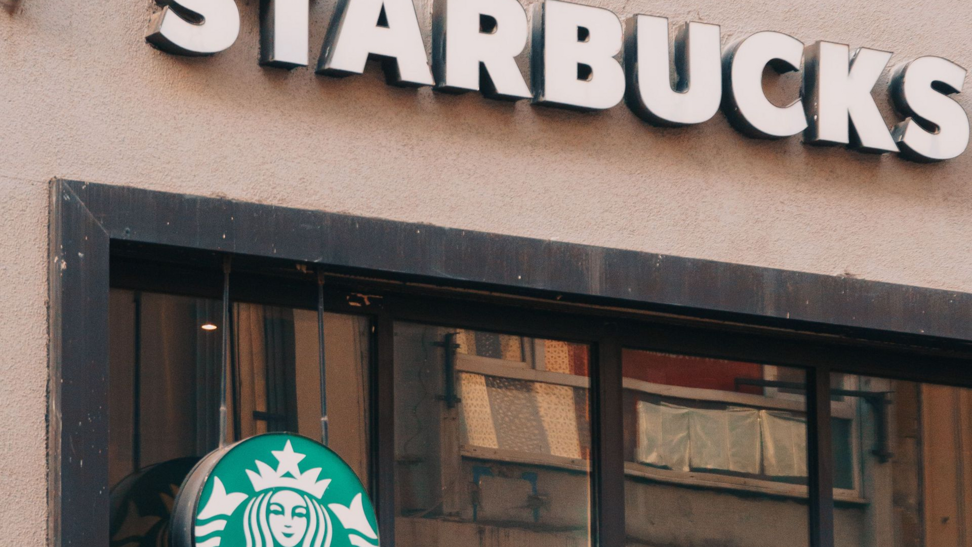 Starbucks storefront with logo sign above windows and entrance.