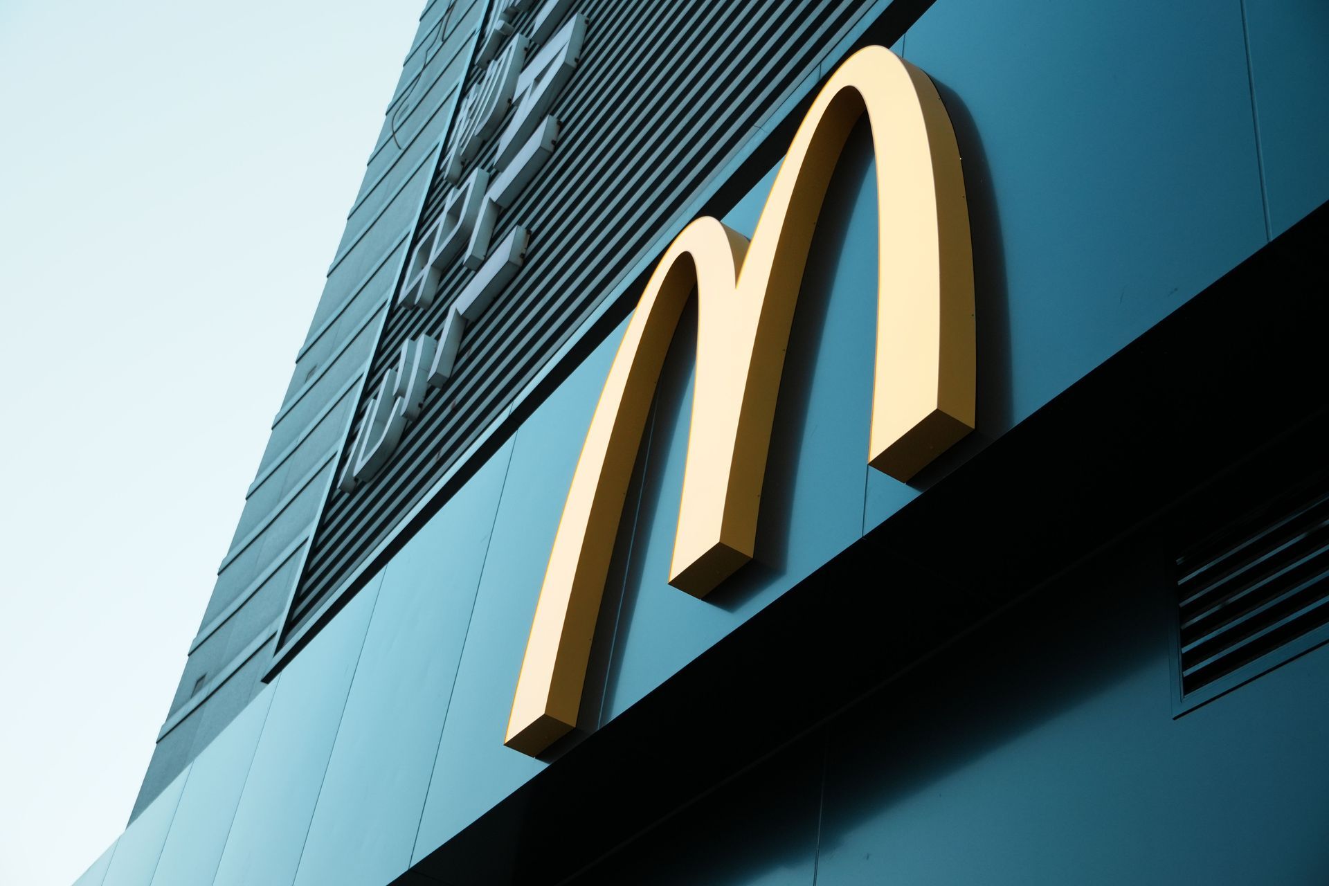 McDonald’s golden arches sign on a blue building facade