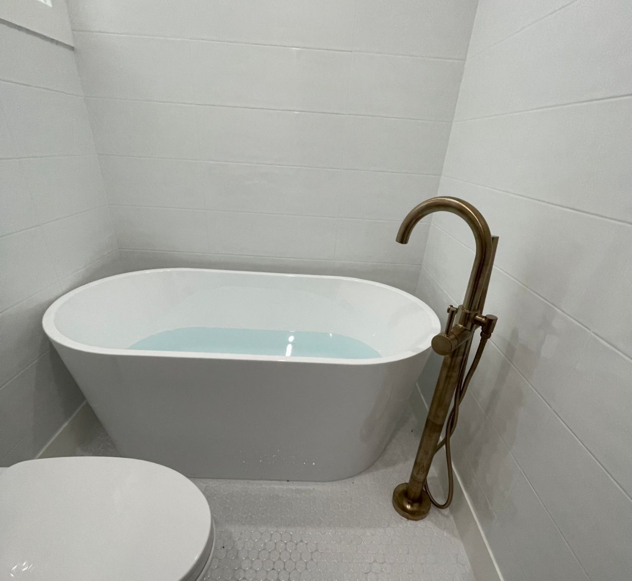 There is a bathtub in the bathroom next to a toilet.