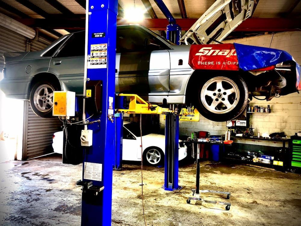 A Car is on a Lift in a Garage With a Snap on Sticker on the Side — AWS Mechanical in Stuart Park, NT