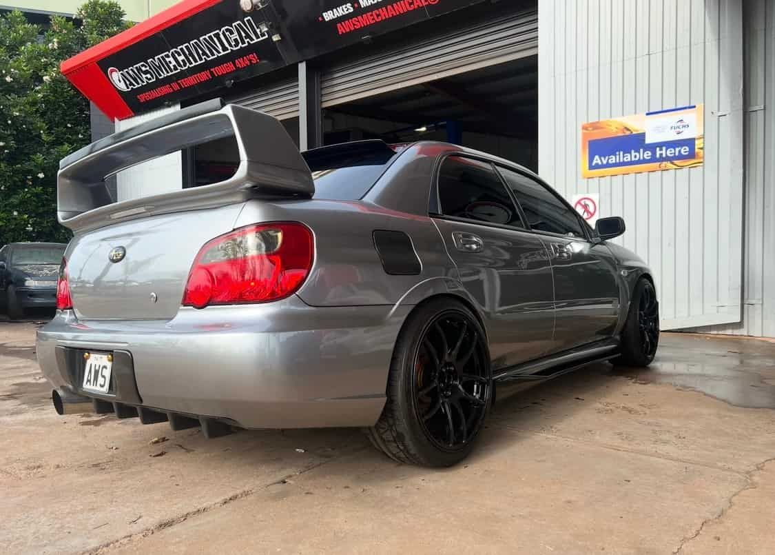 A Silver Car With a Spoiler on the Back is Parked in Front of a Garage — AWS Mechanical in Stuart Park, NT