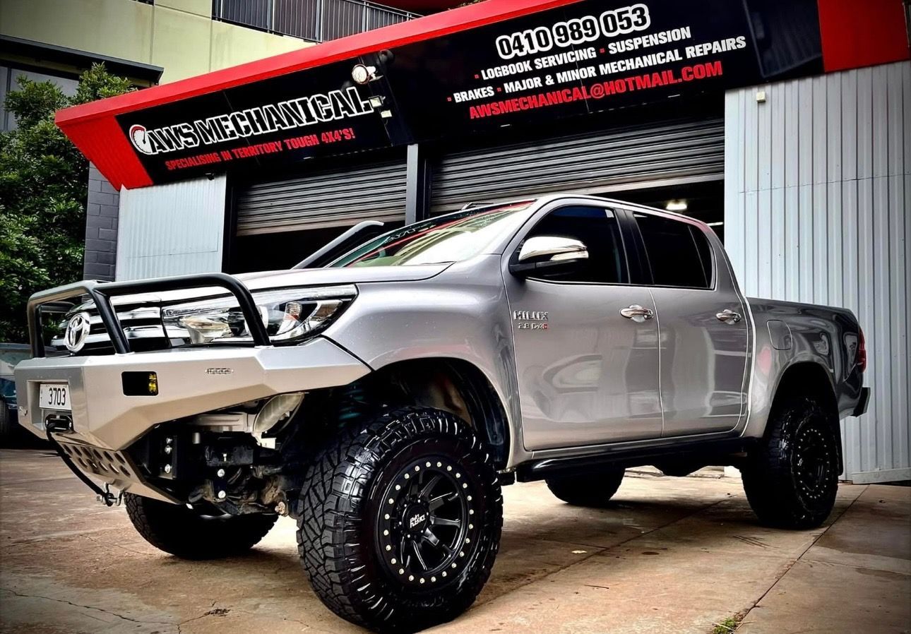 A Silver hilux ute is parked in front of a mechanics garage— AWS Mechanical in Stuart Park, NT