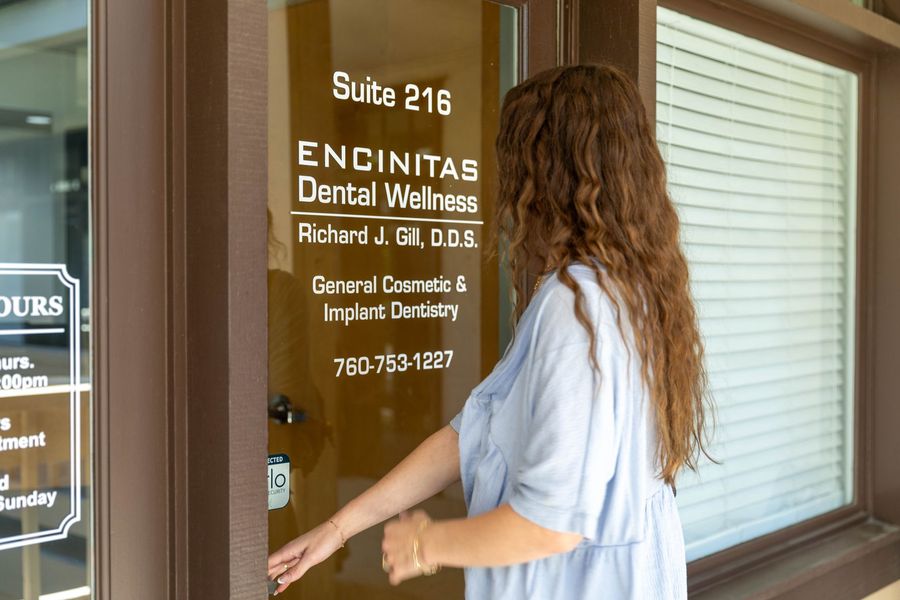 Woman opening door to Encinitas Dental Windows suite entrance