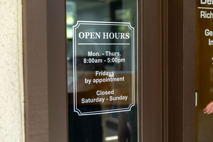 Door sign listing open hours: Mon–Thurs 8:00am–5:00pm, Fridays by appointment, closed Saturday and Sunday