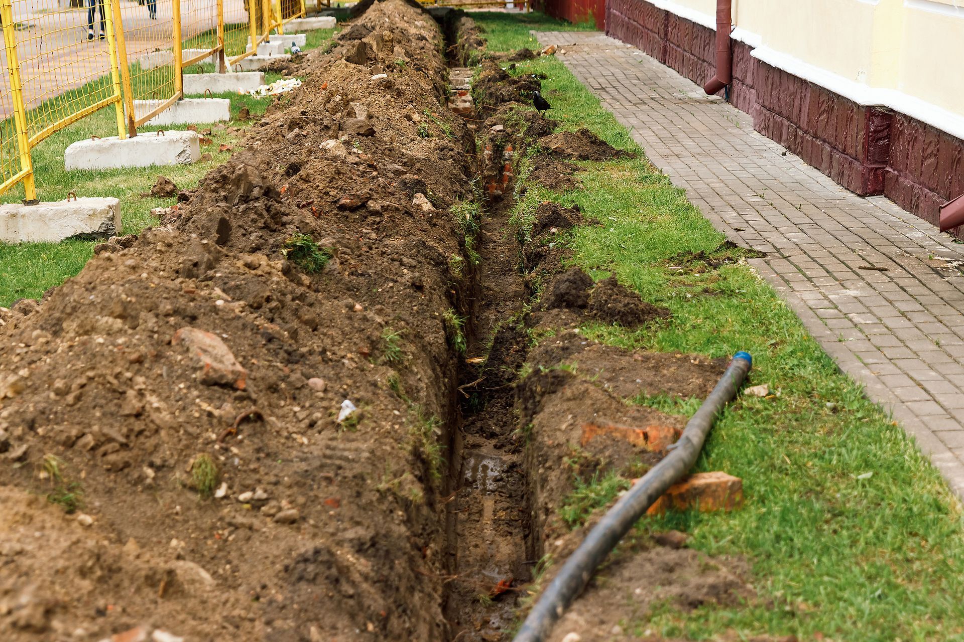 A drainage system is being installed on the side of a building.
