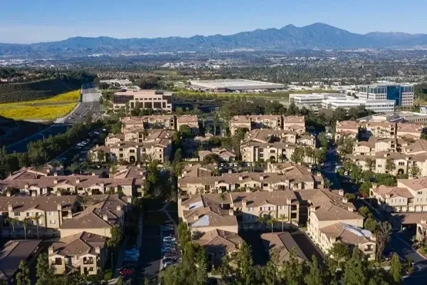 An aerial view of a residential area with mountains in the background.
