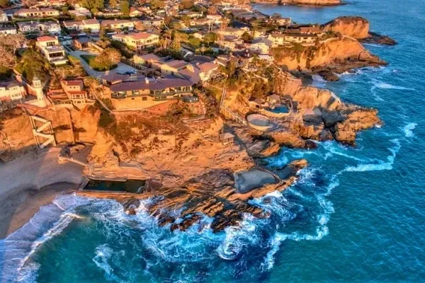 An aerial view of a city on a cliff overlooking the ocean.