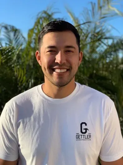 A man wearing a white shirt with the letter g on it