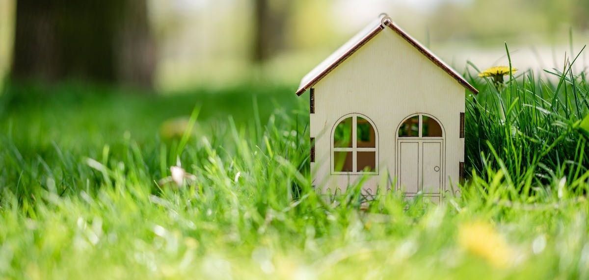 A small wooden house is sitting in the grass.