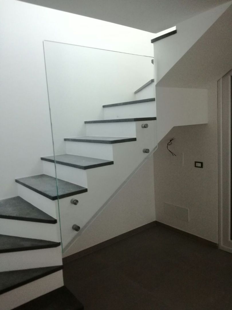 Scala moderna bianca con gradini scuri in un corridoio interno minimalista