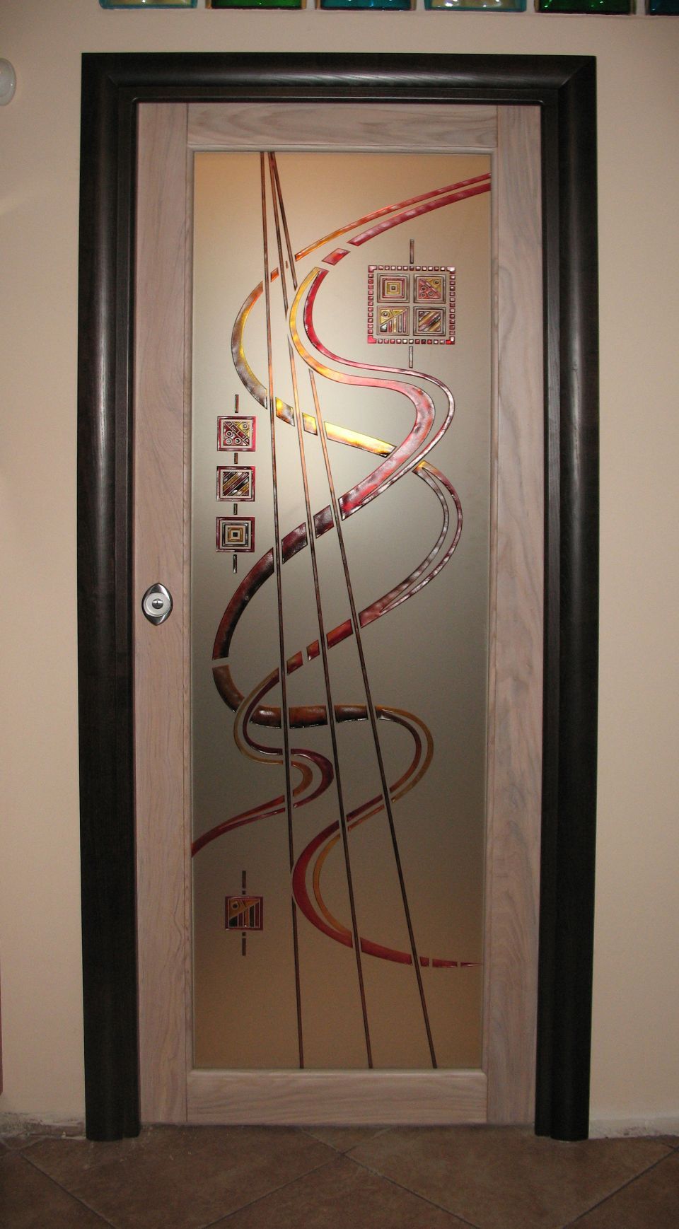 Porta con un disegno astratto a linee ondulate rosse e nere su pannello di vetro satinato.