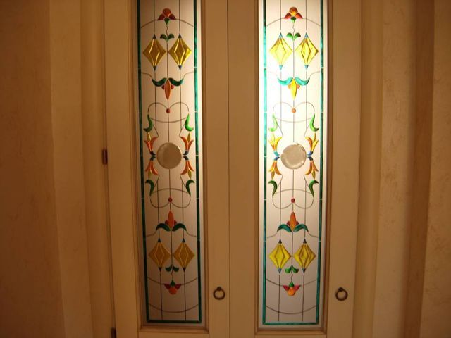 Ante di mobili in legno con pannelli floreali in vetro colorato giallo, verde e rosso