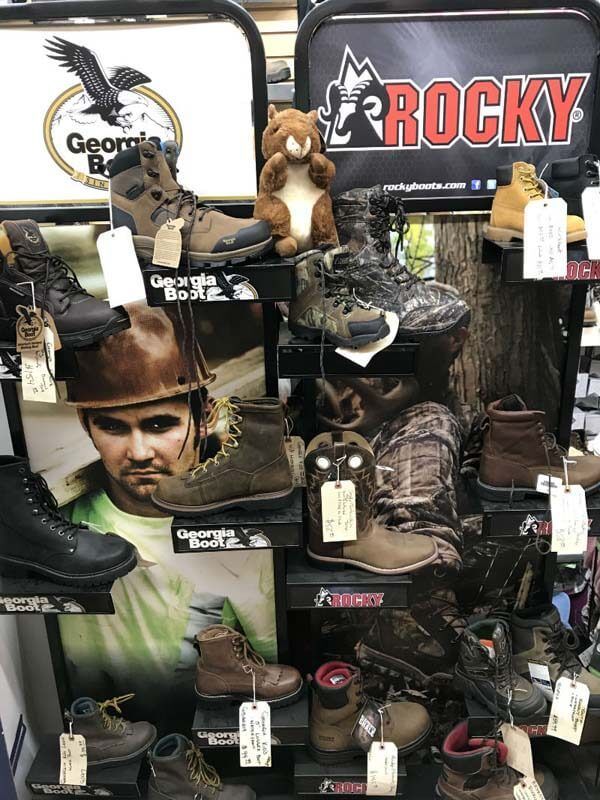 Display of Rocky work boots and camouflage hunting shoes with tags in a store
