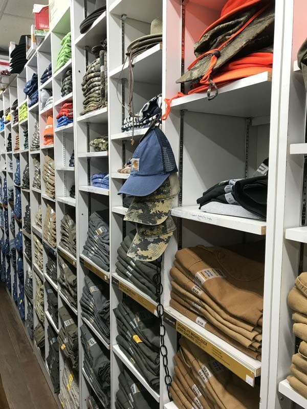 Shelves stocked with folded clothing and bags in a storage room